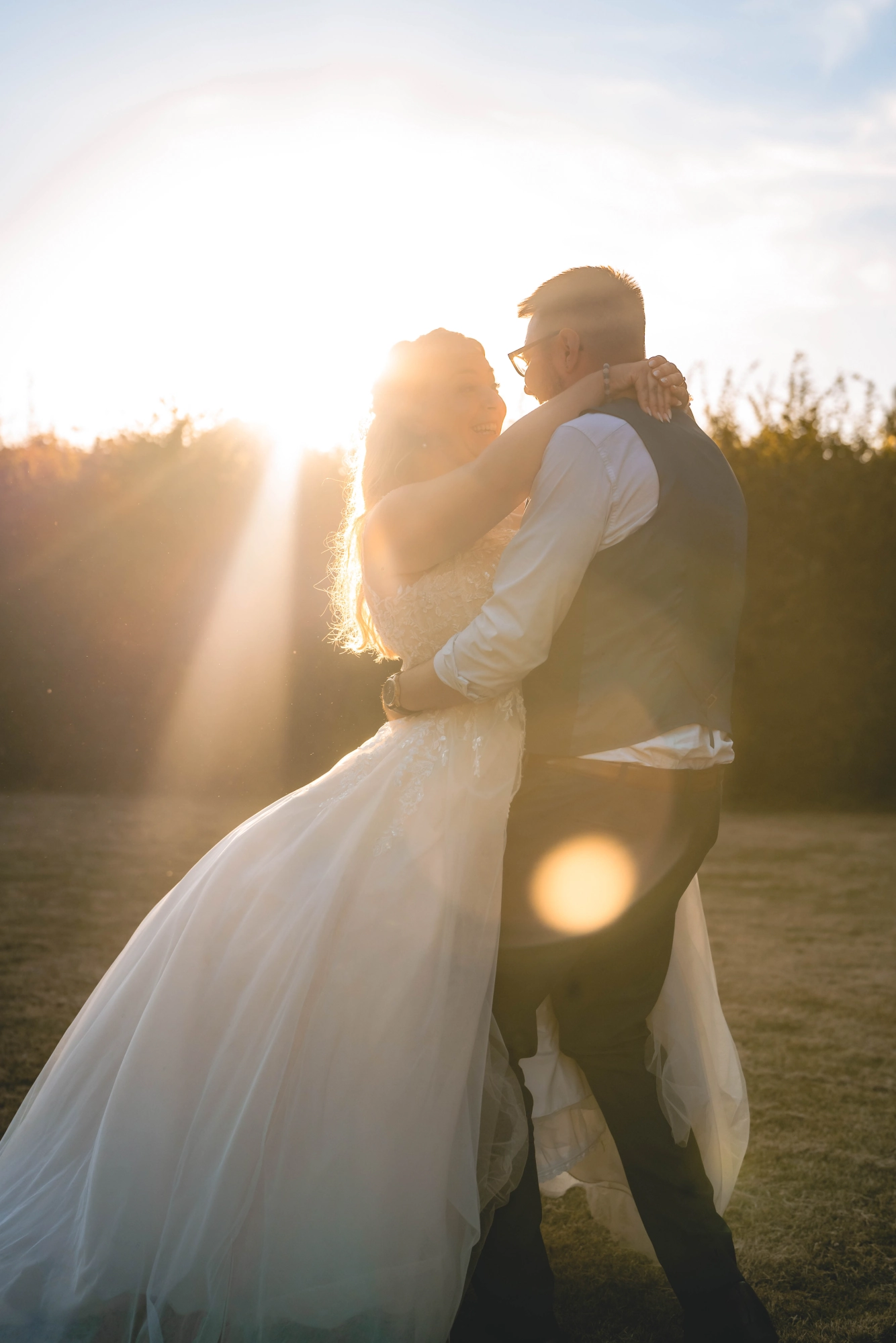 Gros plan couple enlacé avec flare solaire